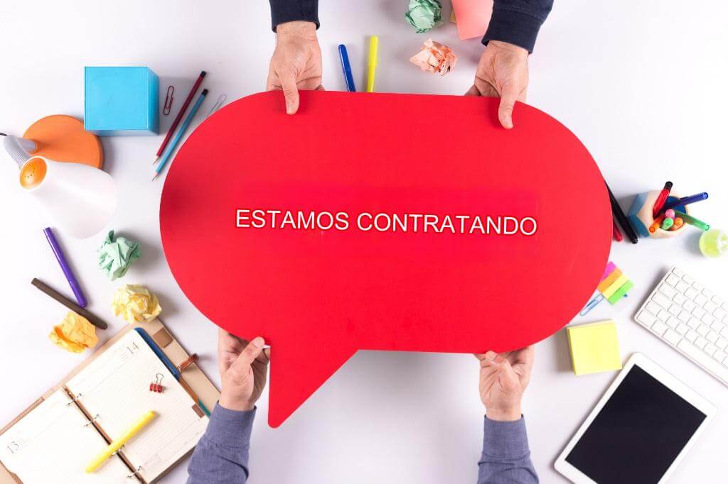 Manos sosteniendo un cartel rojo