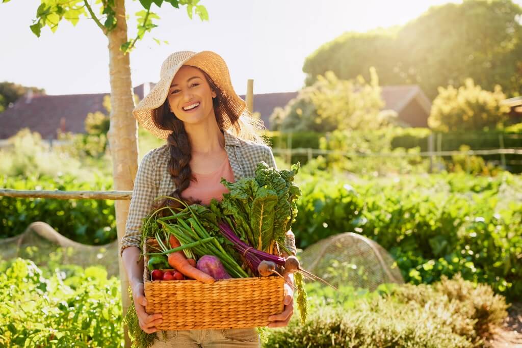 mujer sosteniendo una canasta de verduras
